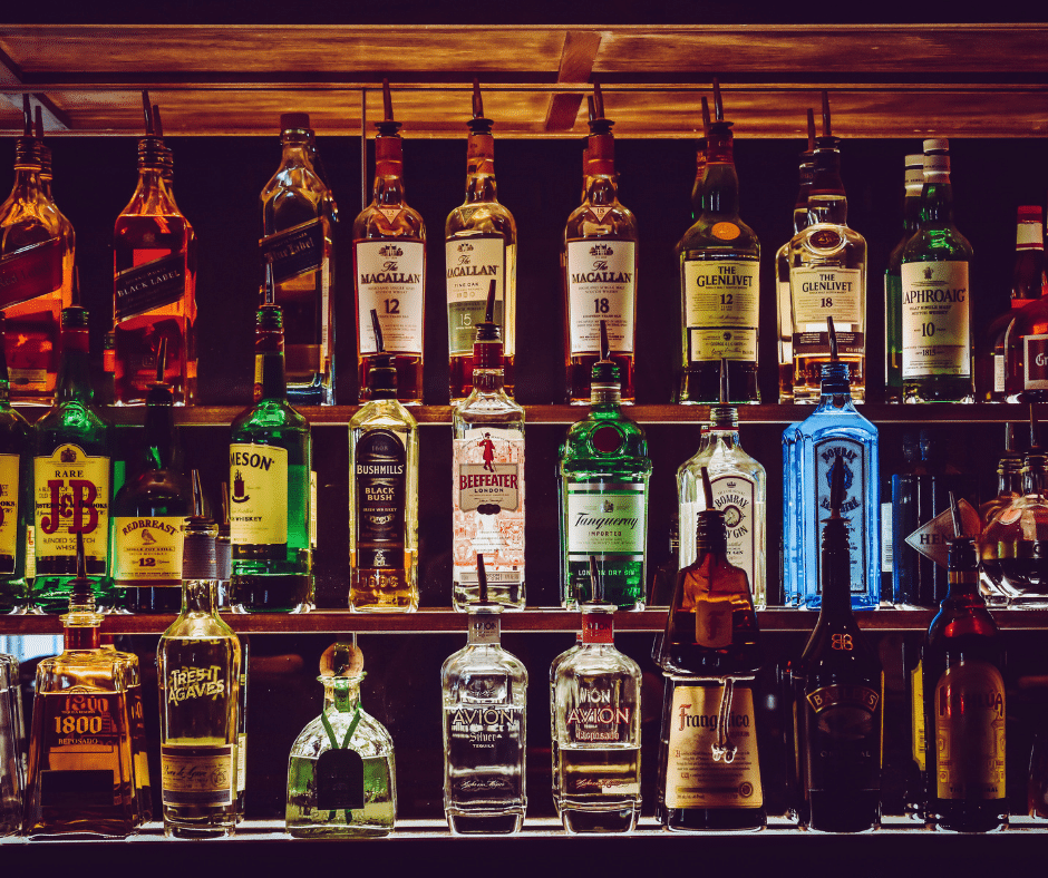 Liquor bottles lined up on a bar's back wall, symbolizing dram shop liability cases handled by Semenza Law