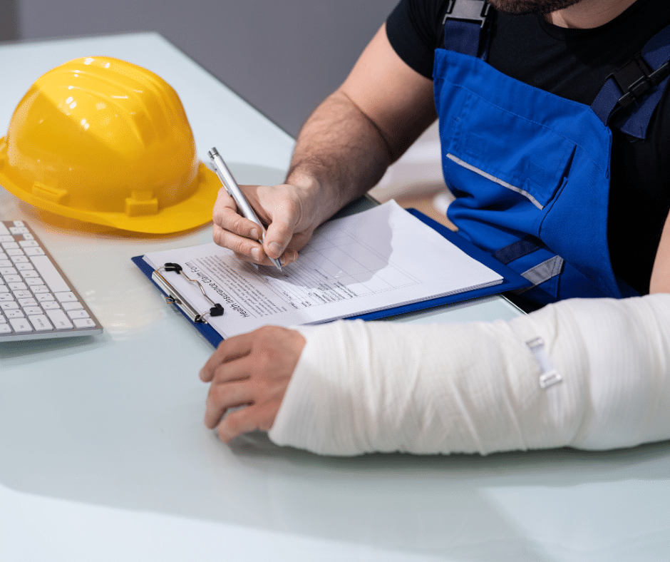 Worker with a cast on their arm filling out a claim form, illustrating workers' compensation cases addressed by Semenza Law.